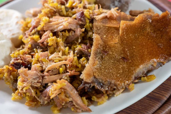 Beyaz tabakta pirinç, arepa ve patates ve bitkilerle dolu bir arka plan..