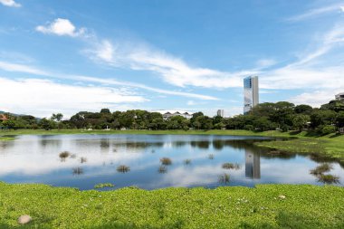 San Jose, Kosta Rika. 8 Ağustos 2021: La Sabana parkının güzel manzarası suda mavi gökyüzünün yansıması. 
