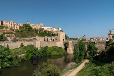 Toledo, Espaa. April 29, 2022:Alcantara Roman Bridge with landscape and blue sky.