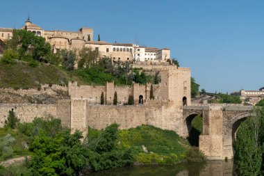 Toledo, Espaa. April 29, 2022:Alcantara Roman Bridge with landscape and blue sky.