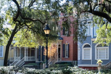Savannah, Georgia, Usa. 2 Aralık 2022: Koloni evlerinin mimarisi ve mavi gökyüzü ile renkli cepheler.