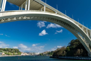 Oporto, Portekiz. 13 Nisan 2022: Arrbida Köprüsü ve mavi gökyüzü ile şehir manzarası.