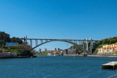 Oporto, Portekiz. 13 Nisan 2022: Arrbida Köprüsü ve mavi gökyüzü ile şehir manzarası.