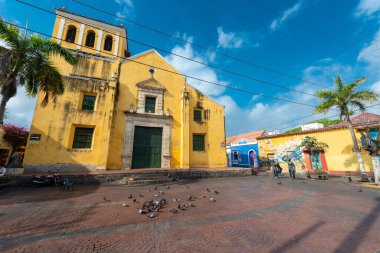 Cartagena, Bolivar, Kolombiya. 15 Mart 2023: Mavi gökyüzü ile park ve üçlü kilise.
