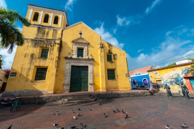 Cartagena, Bolivar, Kolombiya. 15 Mart 2023: Mavi gökyüzü ile park ve üçlü kilise.