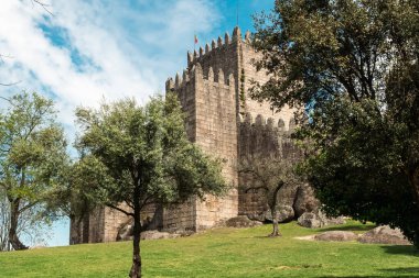 Guimaraes, Portekiz. 14 Nisan 2022: Mavi gökyüzü ile Guimares Kalesi 'nin duvarları ve yapıları.