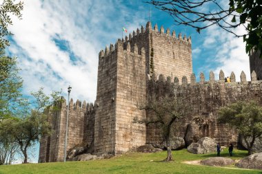 Guimaraes, Portekiz. 14 Nisan 2022: Mavi gökyüzü ile Guimares Kalesi 'nin duvarları ve yapıları.
