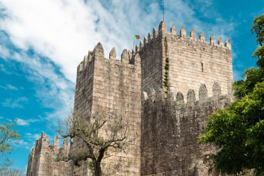 Guimaraes, Portekiz. 14 Nisan 2022: Mavi gökyüzü ile Guimares Kalesi 'nin duvarları ve yapıları.
