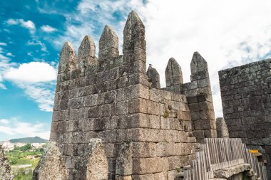 Guimaraes, Portekiz. 14 Nisan 2022: Mavi gökyüzü ile Guimares Kalesi 'nin duvarları ve yapıları.