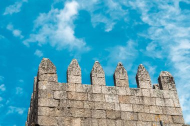 Guimaraes, Portekiz. 14 Nisan 2022: Mavi gökyüzü ile Guimares Kalesi 'nin duvarları ve yapıları.