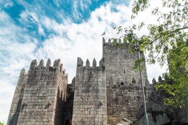 Guimaraes, Portekiz. 14 Nisan 2022: Mavi gökyüzü ile Guimares Kalesi 'nin duvarları ve yapıları.