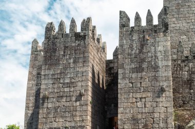 Guimaraes, Portekiz. 14 Nisan 2022: Mavi gökyüzü ile Guimares Kalesi 'nin duvarları ve yapıları.