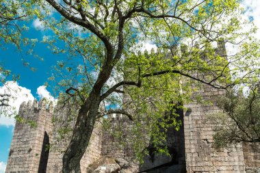 Guimaraes, Portekiz. 14 Nisan 2022: Mavi gökyüzü ile Guimares Kalesi 'nin duvarları ve yapıları.