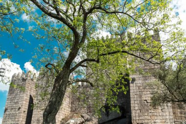 Guimaraes, Portekiz. 14 Nisan 2022: Mavi gökyüzü ile Guimares Kalesi 'nin duvarları ve yapıları.