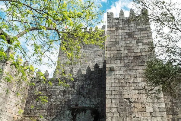 Guimaraes, Portekiz. 14 Nisan 2022: Mavi gökyüzü ile Guimares Kalesi 'nin duvarları ve yapıları.