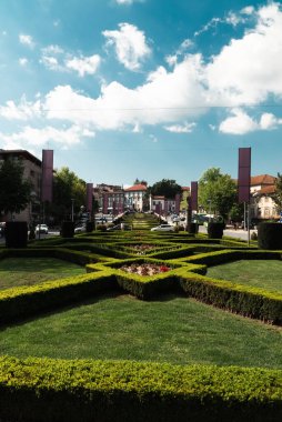 Guimaraes, Portekiz. 14 Nisan 2022: Mavi gökyüzü ve bahçeli Largo da Oliveira.