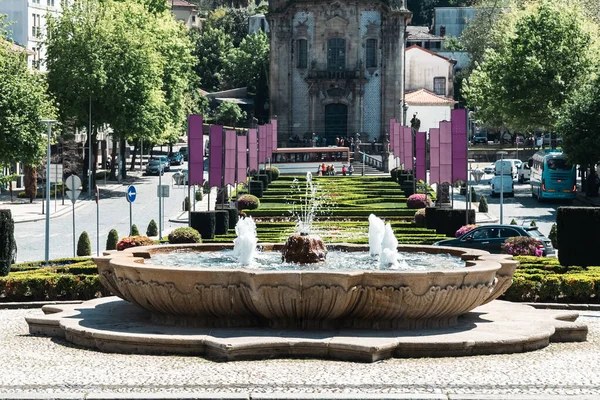 Guimaraes, Portekiz. 14 Nisan 2022: Mavi gökyüzü ve bahçeli Largo da Oliveira.