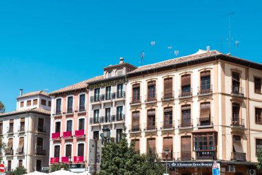 Granada, İspanya. 14 Nisan 2022: Granada şehir merkezinin mimarisi bir yaz günü ve mavi gökyüzü.
