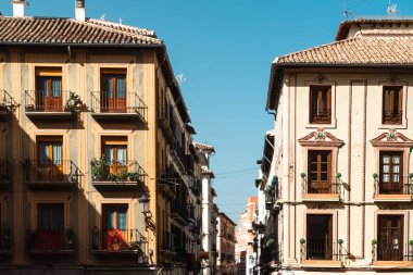 Granada, İspanya. 14 Nisan 2022: Granada şehir merkezinin mimarisi bir yaz günü ve mavi gökyüzü.