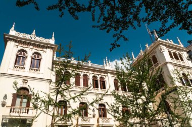 Granada, İspanya. 14 Nisan 2022: Granada şehir merkezinin mimarisi bir yaz günü ve mavi gökyüzü.