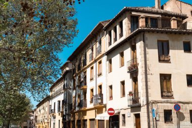 Granada, İspanya. 14 Nisan 2022: Granada şehir merkezinin mimarisi bir yaz günü ve mavi gökyüzü.