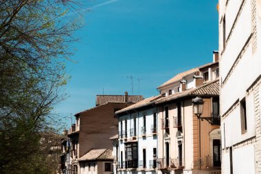 Granada, İspanya. 14 Nisan 2022: Granada şehir merkezinin mimarisi bir yaz günü ve mavi gökyüzü.