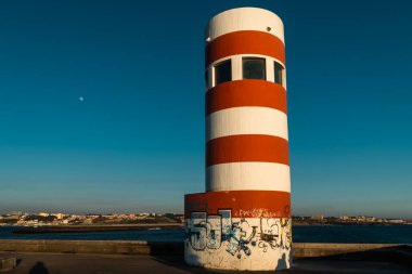 Mavi gökyüzü olan kırmızı ve beyaz deniz feneri. Oporto, Portekiz. 