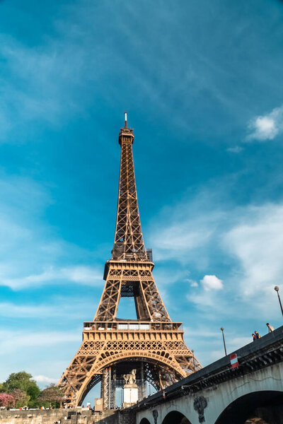 Paris, France. April 22, 2022: Landscape with a view of the Eiffel Tower and beautiful blue summer sky.
