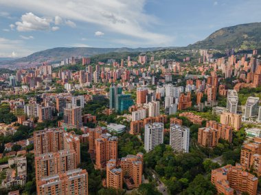 Medellin, Antioquia, Kolombiya. 3 Mayıs 2023: Şehirdeki binalar ve mavi gökyüzüyle manzara.