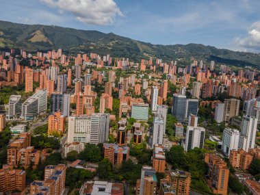 Medellin, Antioquia, Kolombiya. 3 Mayıs 2023: Şehirdeki binalar ve mavi gökyüzüyle manzara.