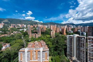 Medellin, Antioquia, Kolombiya. 3 Mayıs 2023: Şehirdeki binalar ve mavi gökyüzüyle manzara.