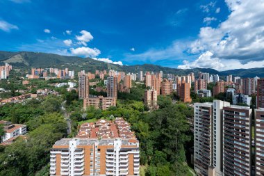 Medellin, Antioquia, Kolombiya. 3 Mayıs 2023: Şehirdeki binalar ve mavi gökyüzüyle manzara.