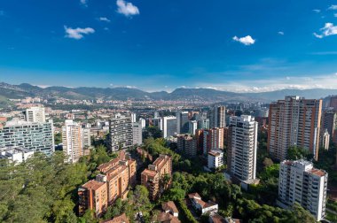 Medellin, Antioquia, Kolombiya. 3 Mayıs 2023: Şehirdeki binalar ve mavi gökyüzüyle manzara.