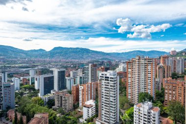 Medellin, Antioquia, Kolombiya. 3 Mayıs 2023: Şehirdeki binalar ve mavi gökyüzüyle manzara.