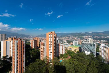 Medellin, Antioquia, Kolombiya. 3 Mayıs 2023: Şehirdeki binalar ve mavi gökyüzüyle manzara.
