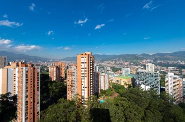 Medellin, Antioquia, Kolombiya. 3 Mayıs 2023: Şehirdeki binalar ve mavi gökyüzüyle manzara.