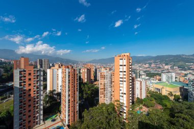 Medellin, Antioquia, Kolombiya. 3 Mayıs 2023: Şehirdeki binalar ve mavi gökyüzüyle manzara.