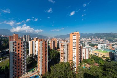 Medellin, Antioquia, Kolombiya. 3 Mayıs 2023: Şehirdeki binalar ve mavi gökyüzüyle manzara.