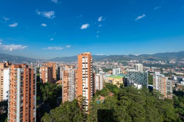 Medellin, Antioquia, Kolombiya. 3 Mayıs 2023: Şehirdeki binalar ve mavi gökyüzüyle manzara.