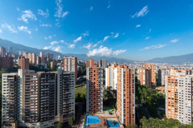 Medellin, Antioquia, Kolombiya. 3 Mayıs 2023: Şehirdeki binalar ve mavi gökyüzüyle manzara.