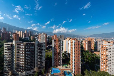 Medellin, Antioquia, Kolombiya. 3 Mayıs 2023: Şehirdeki binalar ve mavi gökyüzüyle manzara.