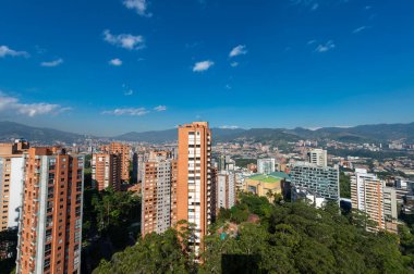 Medellin, Antioquia, Kolombiya. 3 Mayıs 2023: Şehirdeki binalar ve mavi gökyüzüyle manzara.