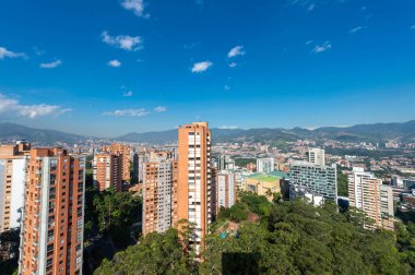 Medellin, Antioquia, Kolombiya. 3 Mayıs 2023: Şehirdeki binalar ve mavi gökyüzüyle manzara.