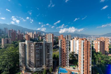Medellin, Antioquia, Kolombiya. 3 Mayıs 2023: Şehirdeki binalar ve mavi gökyüzüyle manzara.