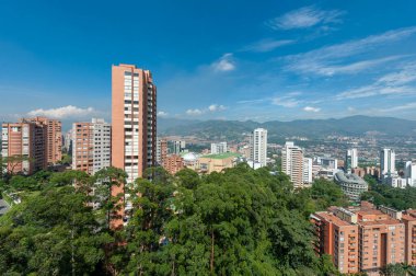 Medellin, Antioquia, Kolombiya. 3 Mayıs 2023: Şehirdeki binalar ve mavi gökyüzüyle manzara.