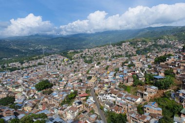 Cali, Valle del Cauca, Kolombiya. 17 Mayıs 2018: MIO ulaşım sisteminin mavi taksisi ve renkli cepheli evler.