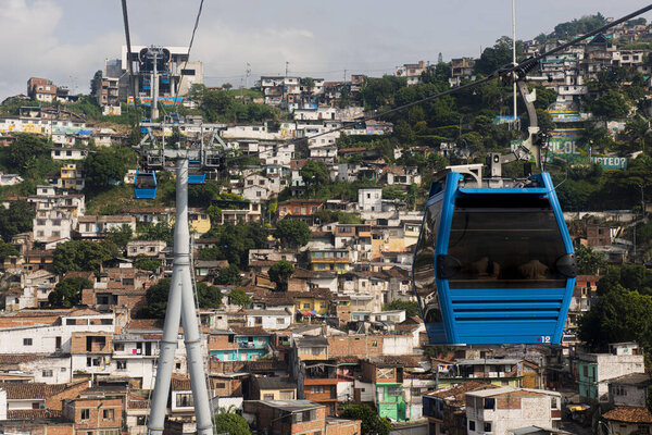 Cali, Valle del Cauca, Colombia. May 17, 2018: Blue cab of MIO transport system and houses with colorful facades.