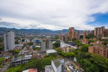 Medellin, Antioquia, Kolombiya. 3 Mayıs 2023: Şehirdeki binalar ve mavi gökyüzüyle manzara.