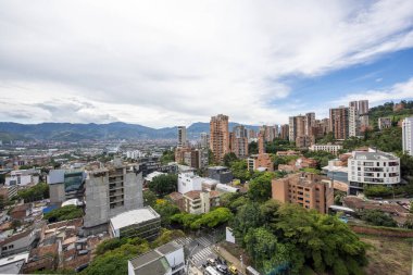 Medellin, Antioquia, Kolombiya. 3 Mayıs 2023: Şehirdeki binalar ve mavi gökyüzüyle manzara.