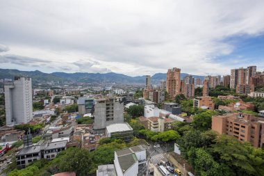 Medellin, Antioquia, Kolombiya. 3 Mayıs 2023: Şehirdeki binalar ve mavi gökyüzüyle manzara.